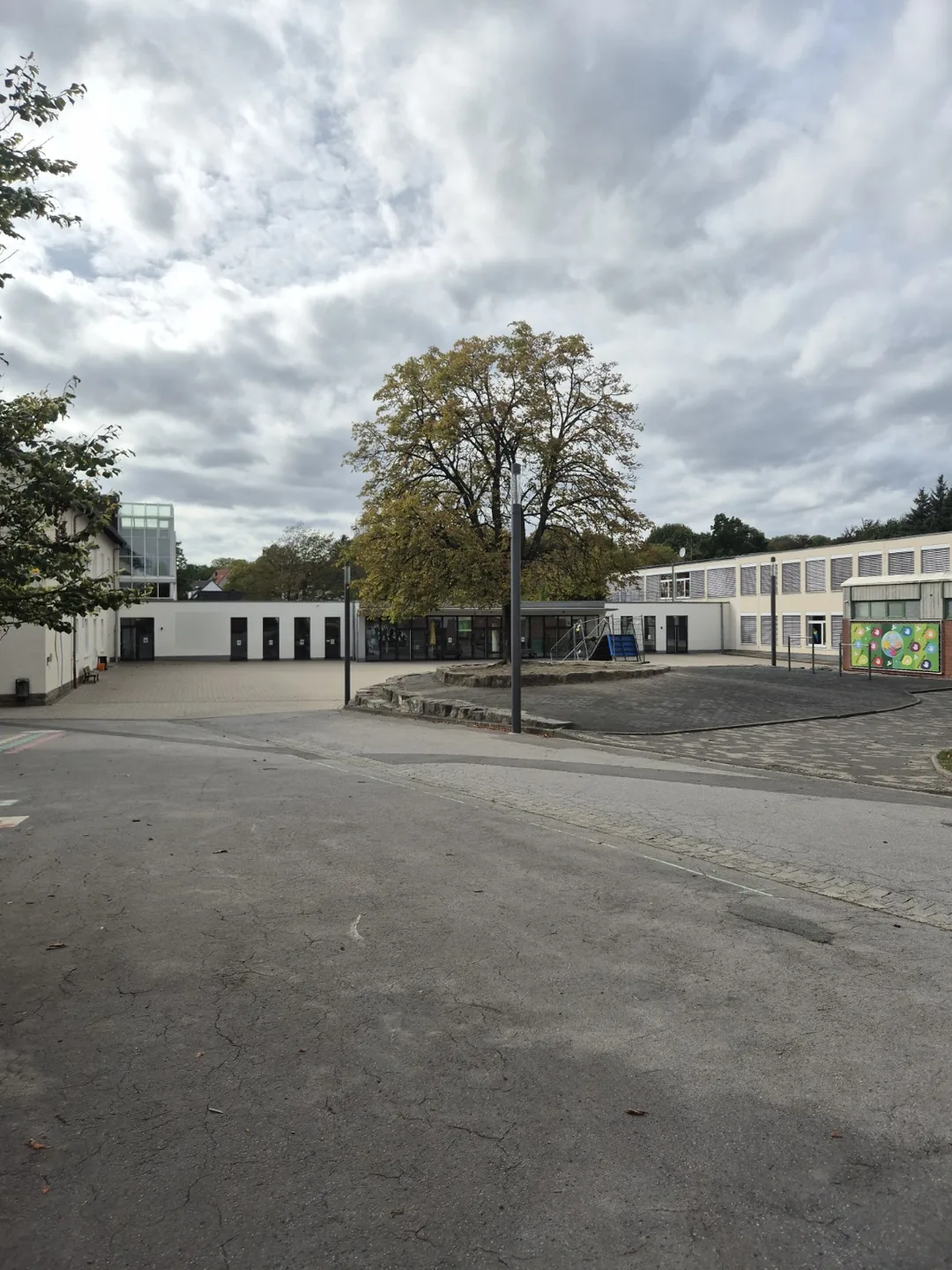 Außenansicht der Grundschule mit mehreren Gebäudeteilen und Glasflächen